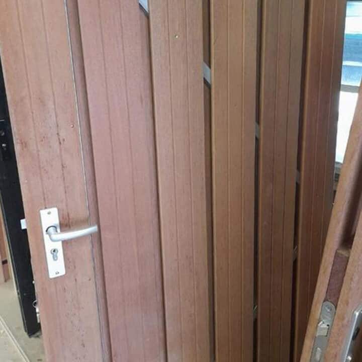 Hardhouten poortdeur met blank stalen frame.